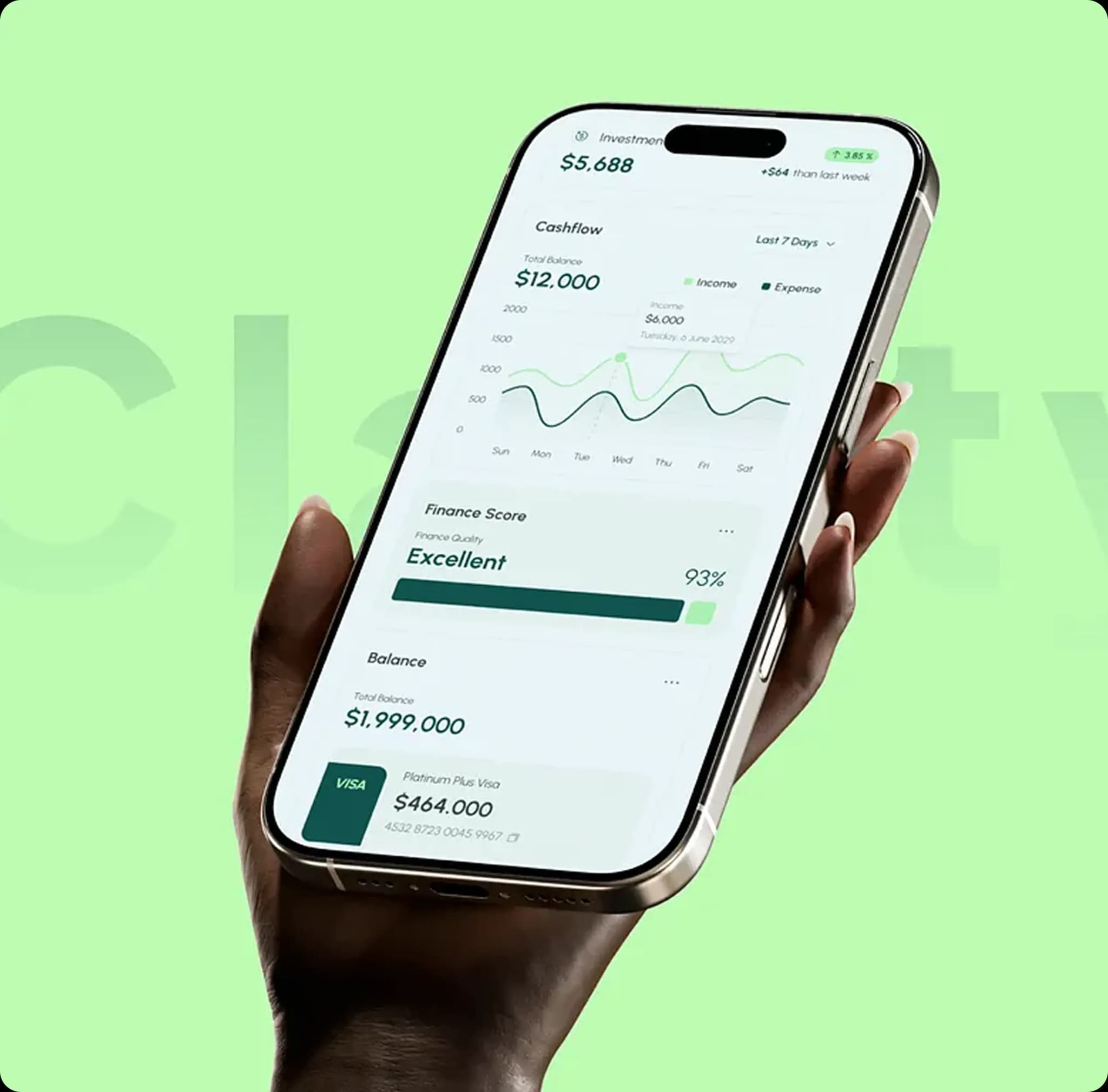 Hand holding smartphone displaying financial app with investment balance, cashflow chart, finance score, and VISA card details.