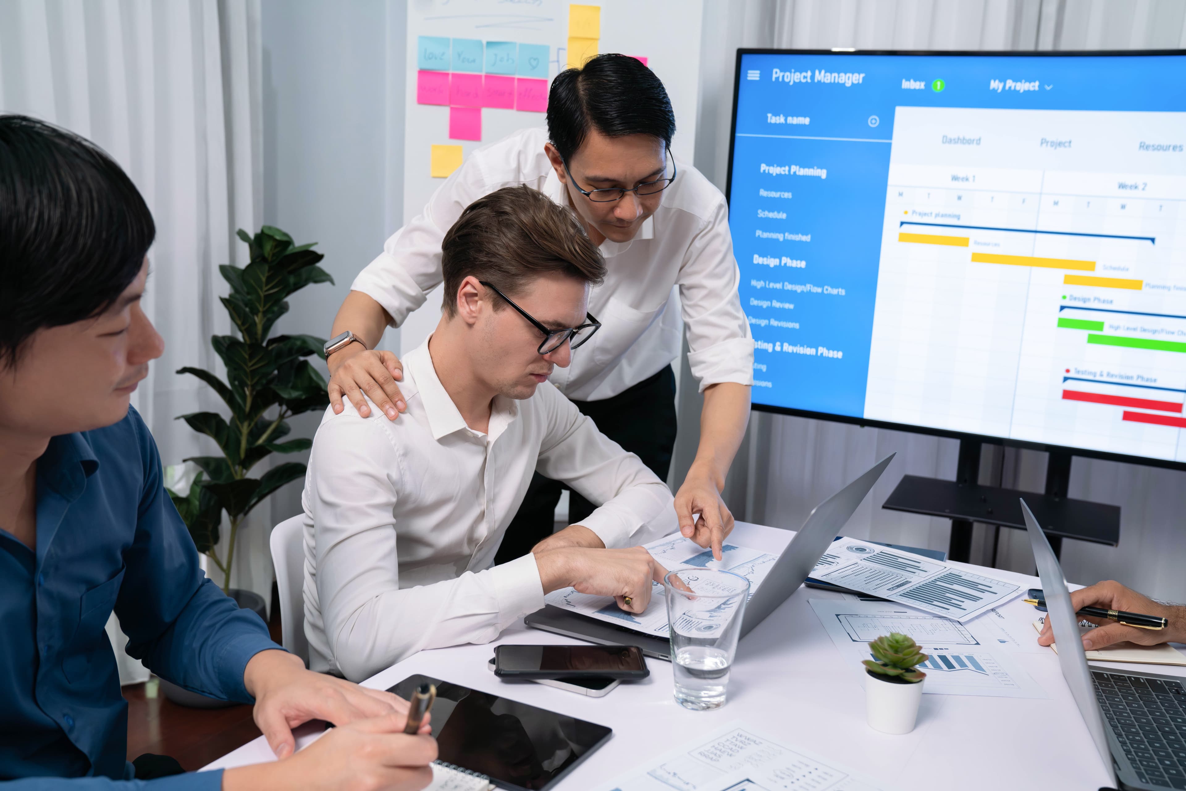 Team reviewing a project management dashboard together on a large screen.