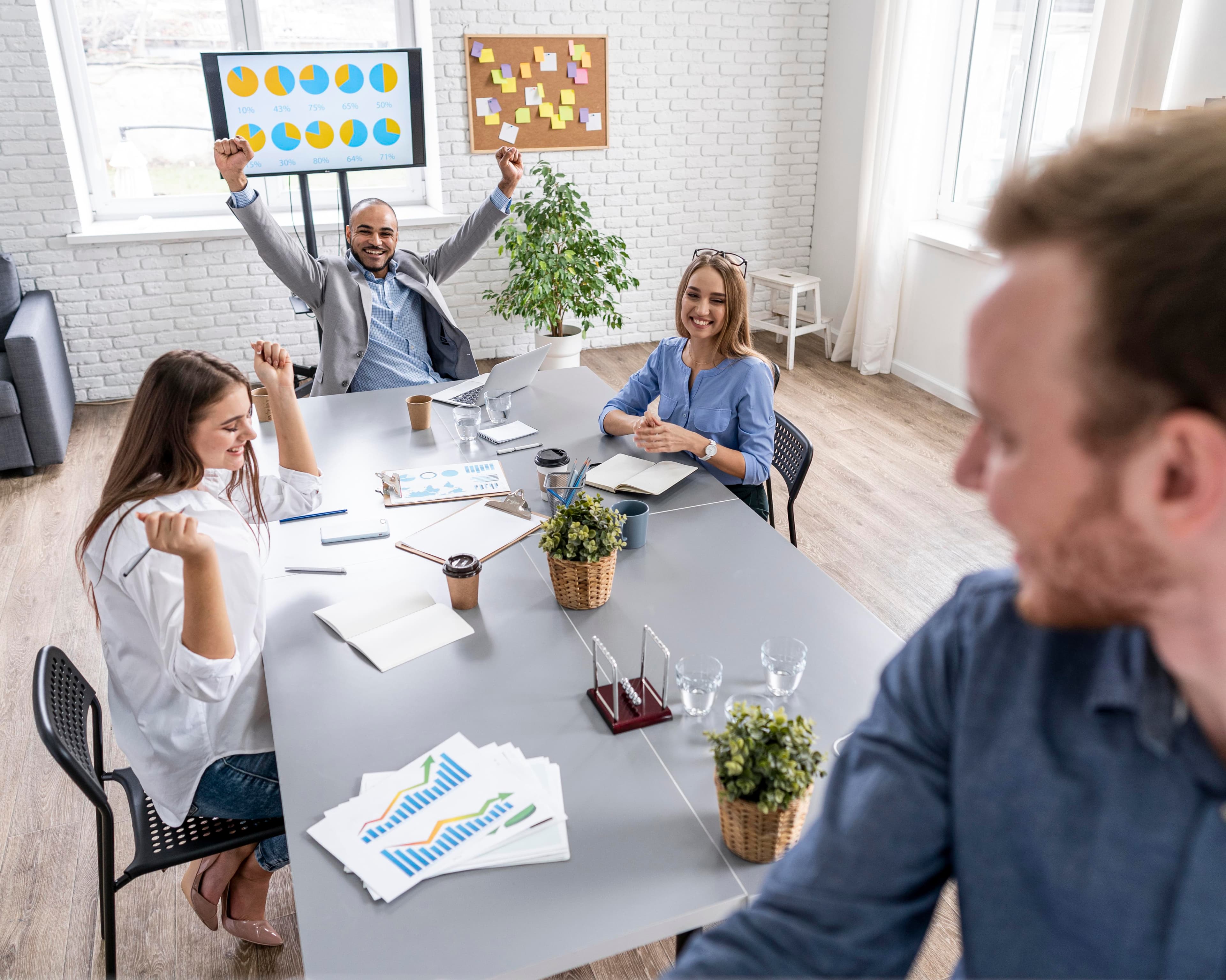 Team celebrating a successful project review in front of a results dashboard.