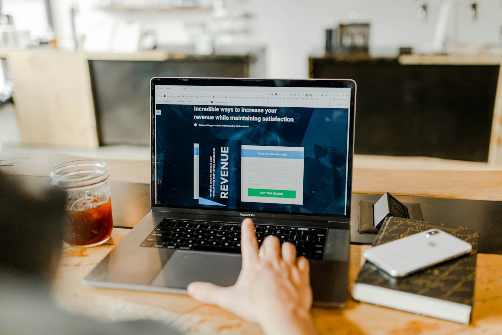 Founder reviewing a revenue landing page on a laptop