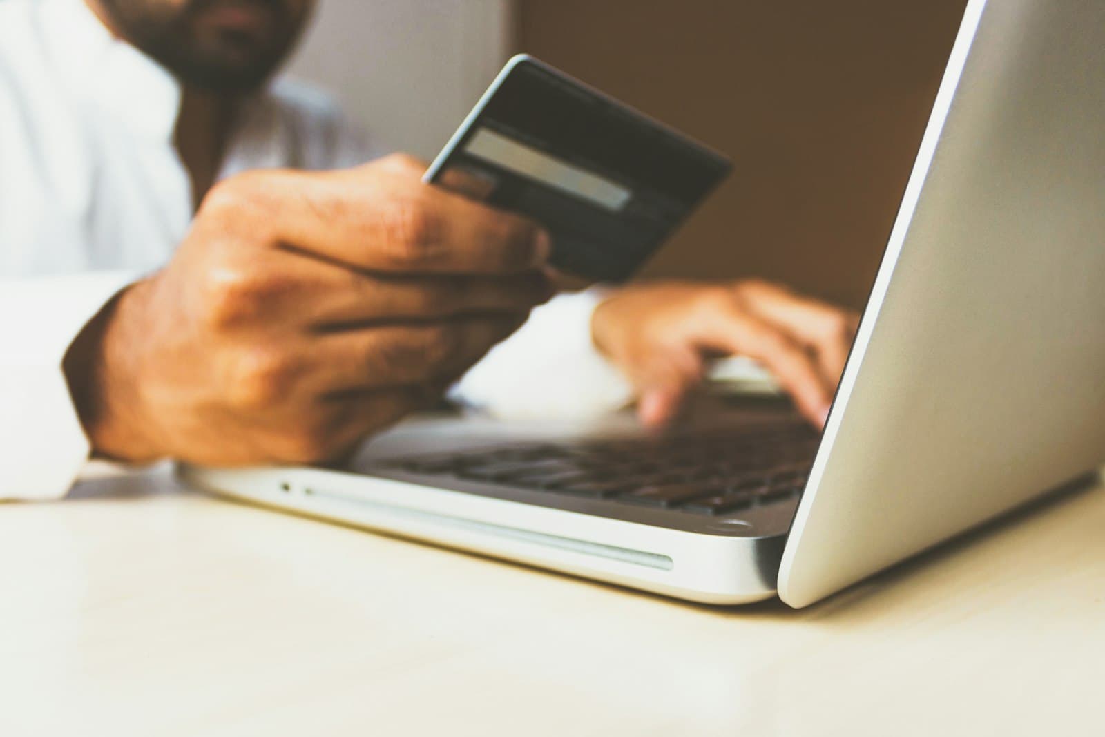 Customer entering card details on a laptop at checkout