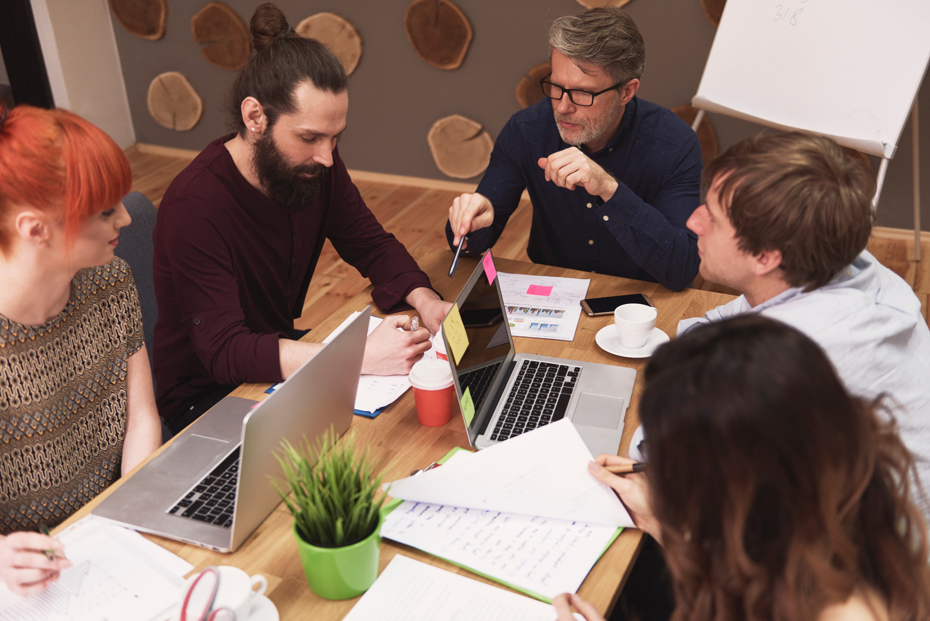 Cozmiq team collaborating around laptops during a work session